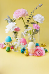 Fototapeta na wymiar Easter eggs, flowers on yellow background