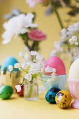 Obraz na płótnie Canvas Easter eggs, flowers on yellow background
