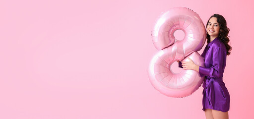Smiling young woman with big balloon in shape of figure 8 on pink background with space for text....