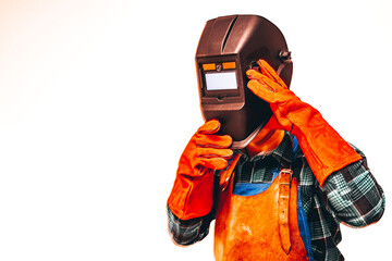 Welder in a protective suit, gloves, taking off his welding mask, Close-up, Place for text