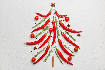 Christmas tree made of hot chili peppers, spices and tomatoes on light background