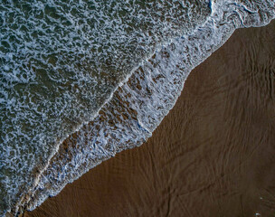 foam water waves of the sea on the shore of the beach sand diagonal mediterranean sunny