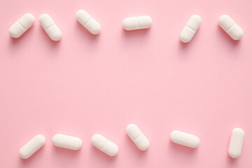 White pills on pink background