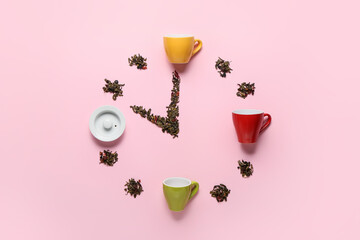 Clock made of cups and dry tea leaves on pink background