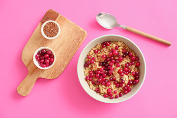 Bowl with tasty oatmeal, flax seeds and cranberries on color background