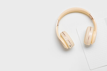 Modern headphones and notebook on white background