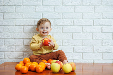 Cute smiling kid eating one fresh juicy red apple. Healthy fruits for young children