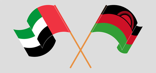 Crossed and waving flags of the United Arab Emirates and Malawi