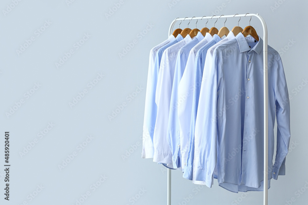 Wall mural Rack with clean shirts on grey background