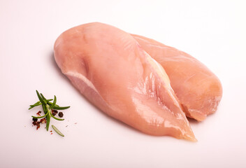 Raw chicken breast, fillet, isolated. Poultry raw meat on a white background, decorated with fresh herbs and seasonings.
