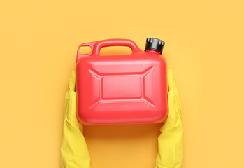 Female hands in rubber gloves with canister on color background