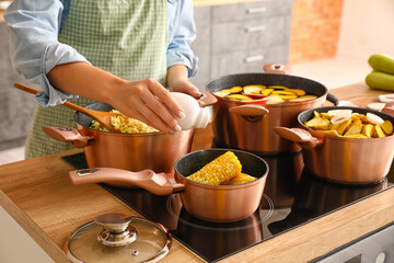 Woman cooking delicious dinner in kitchen