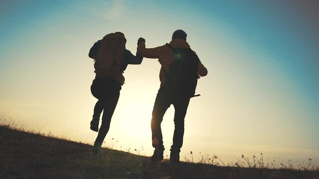 business teamwork a freedom concept. couple of tourists run with silhouette backpacks running jumping. travel freedom business concept. couple sunset teamwork hikers running jumping