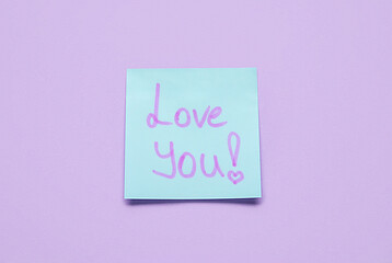 Sticky note with text LOVE YOU on violet background
