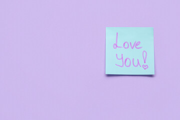 Sticky note with text LOVE YOU on violet background
