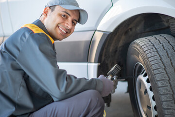 Mechanic checking the pressure of a van tire