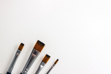 Paint brushes on white canvas. Minimal concept of freedom of creativity and self-expression. Selective focus, copy space