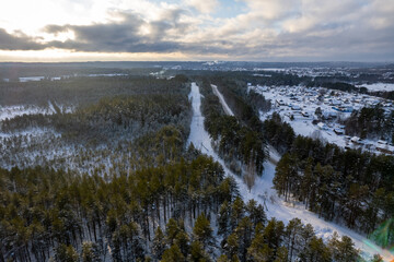 aerial view forest tundra taiga road in the forest in winter on a sunny frosty day in siberia small village. High quality photo