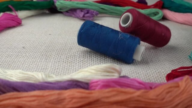 Falling multicolored spools on burlap against the background