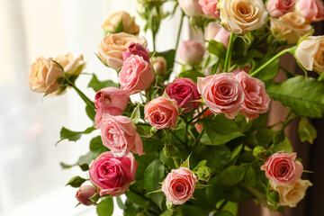 Bouquet of beautiful roses in light room, closeup