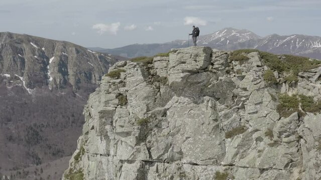 Hiker admiring view from the top of a rocky peak