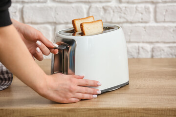 Woman making toasts near white brick wall