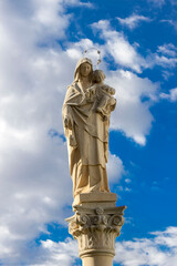 religious statue of the virgin with blue sky background
