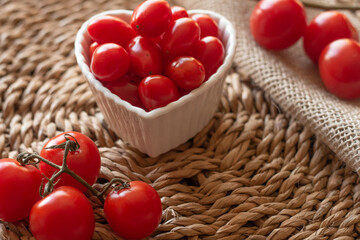 tomatoes inside a white bowl and on to a straw table