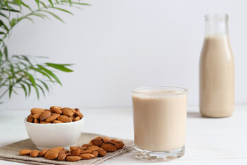 Almond milk in drinking glass on the table. Vegan plant-based product. Healthy food concept, lactose free food. Selective focus