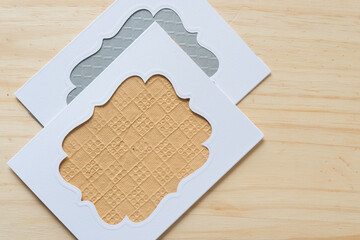 blank cards with fancy window openings on a wooden surface