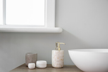 Naklejka na ściany i meble Table with sink and bath accessories near light wall