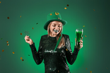 Beautiful woman with clover, glass of beer and falling confetti on green background. St. Patrick's Day celebration