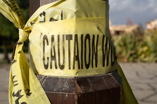 Warning yellow tape with caution word at pillar for construction works