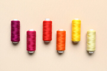 Different sewing threads on beige background
