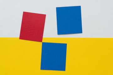 three paper squares on white and yellow