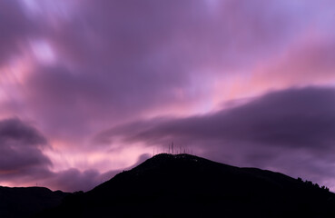 Obraz premium Purple long exposure sunset with Pichincha volcano silhouette seen from Quito city, Ecuador.
