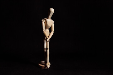 Wooden mannequin hiding genitals. Symbol of wanting to pee or trauma after rape