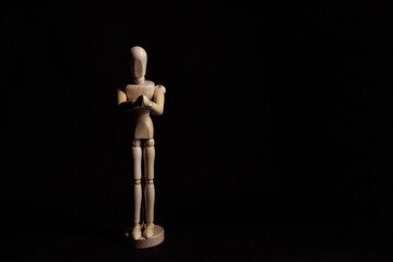 Wooden mannequin with folded hands. Symbol of prayer and religiosity