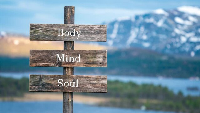 body mind soul text quote on wooden signpost outdoors in nature. Slow pan and zoom 4k video footage.