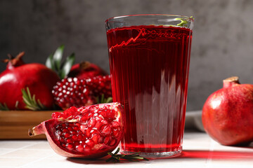Glass of delicious pomegranate juice on table