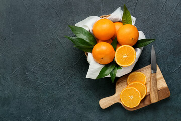 Basket with fresh juicy oranges on black background