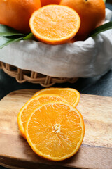 Fototapeta na wymiar Wooden board with slices of fresh orange on table