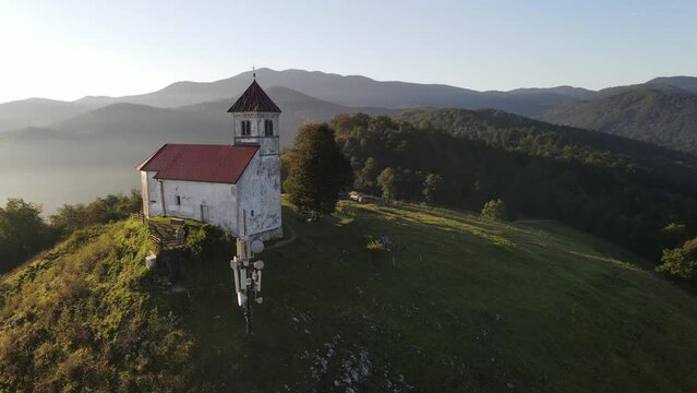 Beautiful sunrise shoot rotating Drone shoot,moody green, green woods, clouds, sunrise , sunny day, woods, afternoon Europa SLOVENIJA, Ljubljana, prodia, from back, church religion
