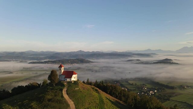 Beautiful sunrise shoot rotating Drone shoot,moody green, green woods, clouds, sunrise , sunny day, woods, afternoon Europa SLOVENIJA, Ljubljana, prodia, from back, church religion vol.2.mov