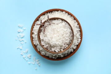 Bowls of sea salt on color background