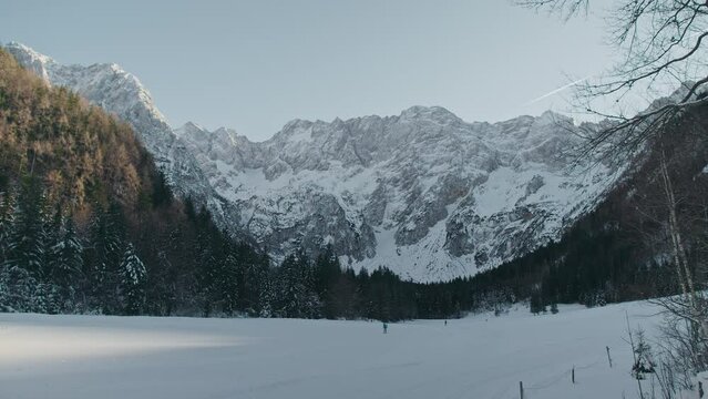 Mountain landscape of beautiful Alpine peaks, cross country trails, and coniferous forest in the snow season, handheld shot.