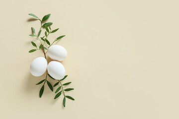 Easter eggs and green branches on beige background