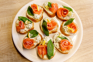 Bruschetta with salmon on a white tray.