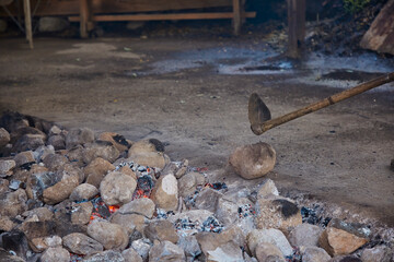 Gaucho with stones heating in a well to cook curanto. Shovel, fire, smoke and rocks. Typical food of the Argentine Patagonia.