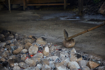Gaucho with stones heating in a well to cook curanto. Shovel, fire, smoke and rocks. Typical food of the Argentine Patagonia.